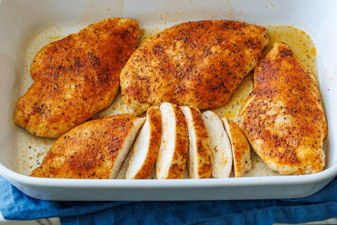 Juicy baked chicken breast served in a white casserole dish